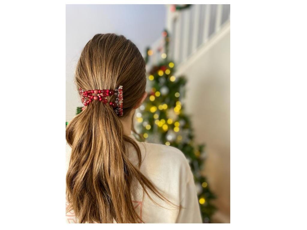 Young Lady wearing our African Butterfly 7 Tong Wire Hair Clip in a simple low ponytail hairstyle standing next to a Christmas Tree