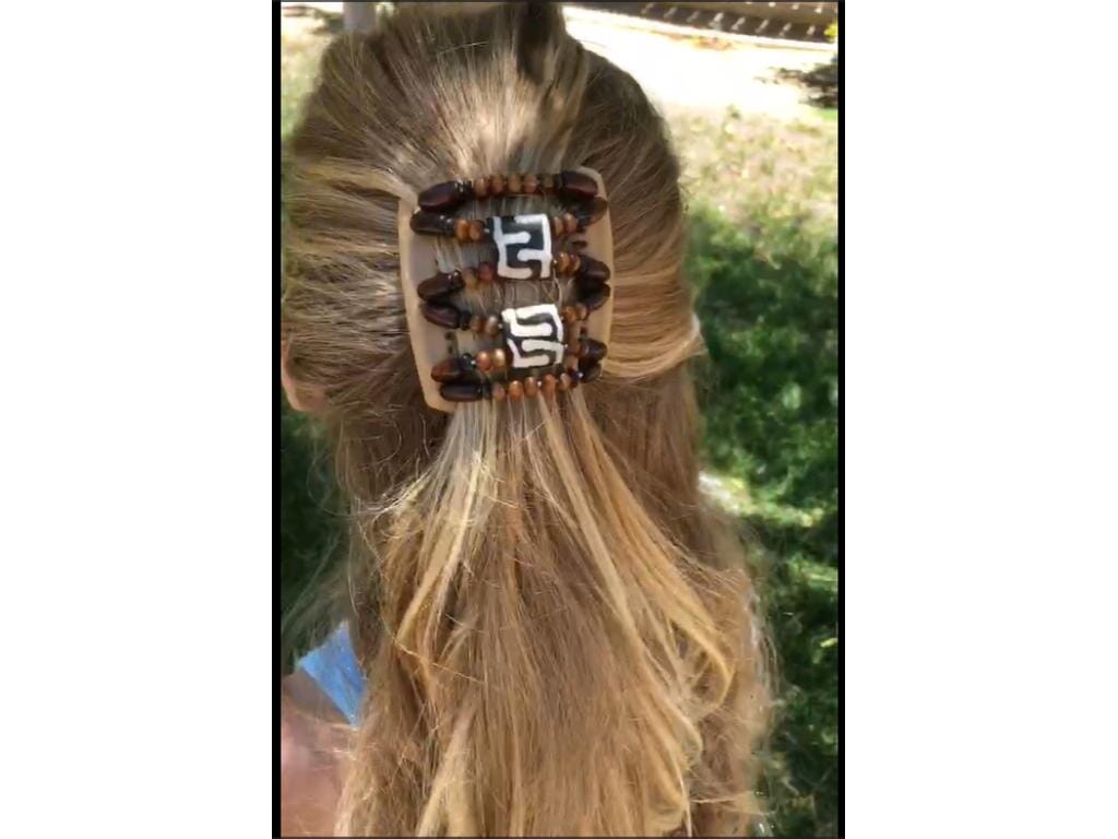 Young girl showcasing our African Butterfly Chameleon Stones & Bones Hair Comb with a sides up hairstyle