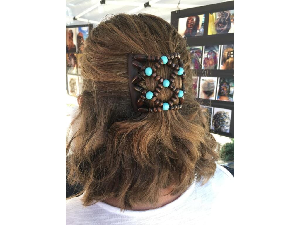 Woman showcasing our African Butterfly Chameleon Ndebele Hair Comb with a sides up hairstyle