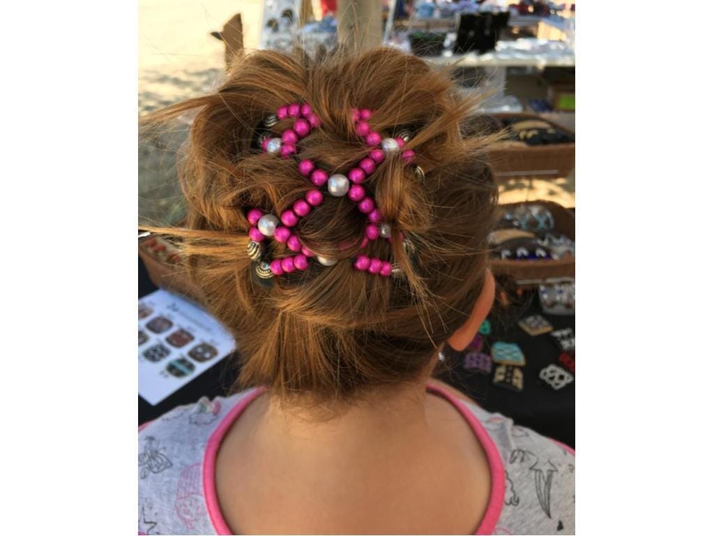Young girl showcasing our African Butterfly Chameleon Ndalena Hair Comb with a messy bun hairstyle