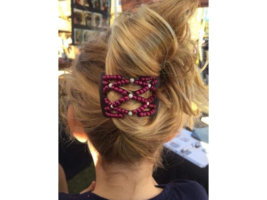 Woman wearing an African Butterfly LadyBug Hair Comb in a bun hairstyle with pink raspberry beads