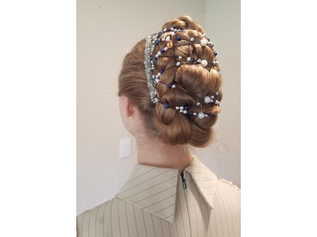 Woman wearing an African Butterfly 11 Tong Wire Hair Clip with blue, silver, and white beads in a braided updo, with a neutral background