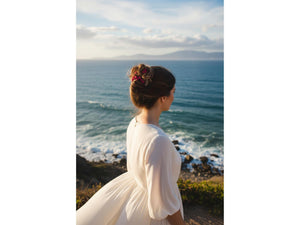 Woman wearing our African Butterfly 7 Tong Wire Hair Clip with fuchsia beads in a french twist hairstyle overlooking the ocean 