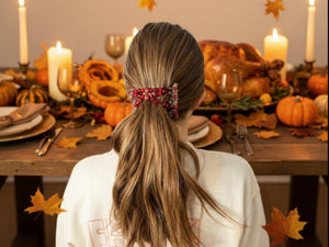 Young Lady wearing our African Butterfly 7 Tong Wire Hair Clip in a simple low ponytail sitting at a Fall table