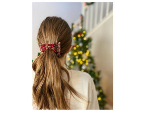 Young Lady wearing our African Butterfly 7 Tong Wire Hair Clip in a simple low ponytail hairstyle standing next to a Christmas Tree