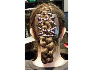 Woman sitting at a desk wearing an African Butterfly Dalena Brown Thick Hair Comb, silver shimmer, mauve, and black with silver beads, in a braided updo