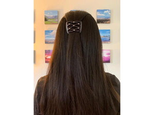 Woman wearing an African Butterfly Black LadyBug Hair Comb with dark grey and white beads in a sides up hairstyle