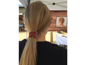 Woman wearing an African Butterfly Black Brown Pearl Hair Comb with red beads in a ponytail hairstyle at a craft show