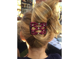 Young girl wearing an African Butterfly Brown LadyBug Hair Comb with maroon and white beads with a french twist hairstyle at a craft show